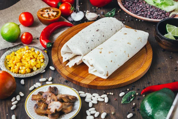 Vegetarisk Burrito Träskiva Över Svart Bord Omgiven Ingredienser — Stockfoto