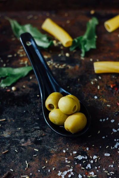 Olivy Černé Lžíci Obklopené Dalšími Ingrediencemi — Stock fotografie