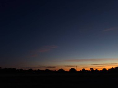 Dramatik bulutlu görkemli akşam gökyüzü ve gün batımından sonra renkli bir eğim..