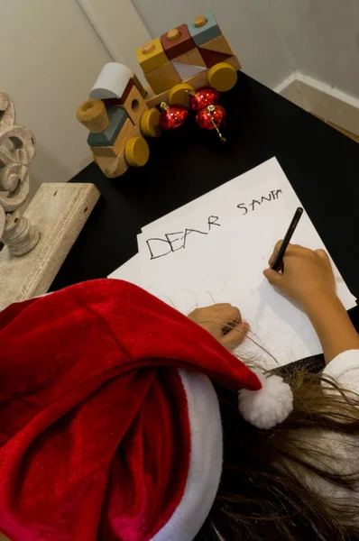 Noel Baba kostümlü kız yere resim çiziyor. Noel ve yeni yıl konsepti