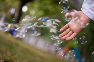 Parktaki bir çocuğun elinde sabun köpüğü