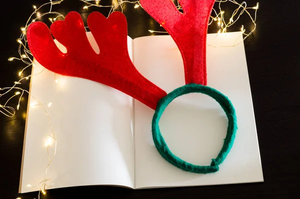 Elinde Noel şapkası ve siyah bir arka planda çelengi olan iki kırmızı kalp.