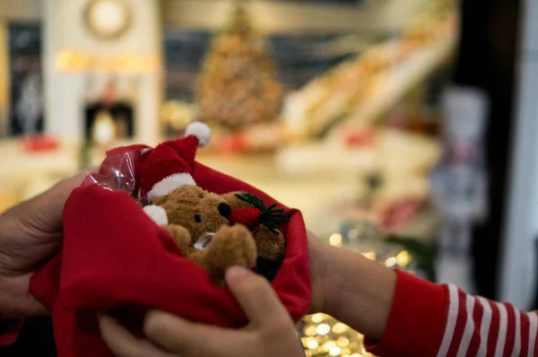 Elinde oyuncak Noel süsü tutan adam.