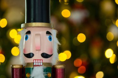 Bir fındık kıracağının yatay görüntüsü ve arka planda bir noel ağacı bulanıklaştırılmış..