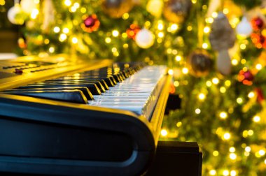 Noel süslemeleri ve Noel ağacı olan piyano klavyesi..