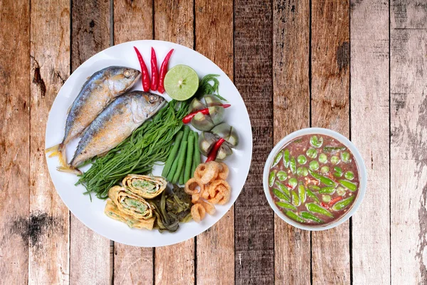 Thai popular cuisine,Spicy shrimp paste dip as Nam Prik Kapi in Thai served with deep fired mackarel,boiled long-eggplant,lentils,vegetable omelet  and sliced cucumber.