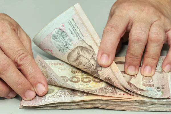 Her iki ellerini birlikte 1000 Baht Tayland banknot sayma kullanarak