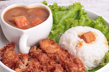 Derin kızarmış tavuk ve tepesinde Japon sarı köri yeşil meşe ile pirinç Yasemin.