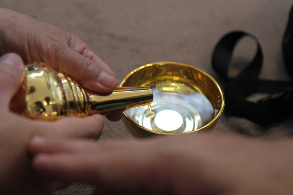 Buddhists make merit,Pouring water from the bottle into the cup, after a good deed and share the wealth to Buddhism. Means to share good to others. Selective focus.