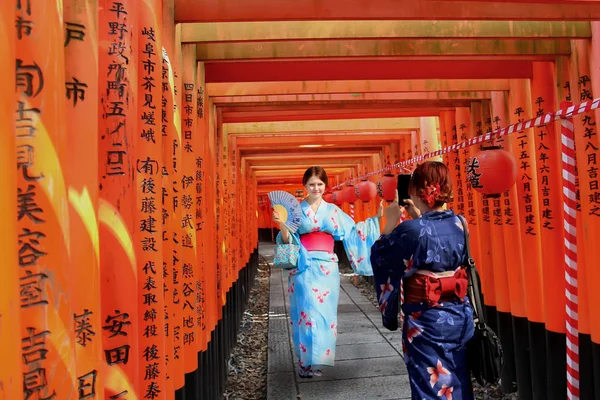 Kimono mulheres estrangeiras post atuando para tirar foto linha torii santo — Fotografia de Stock