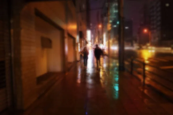 Blurry and soft focus photo of  rainy night view with man and wo — Stock Photo, Image