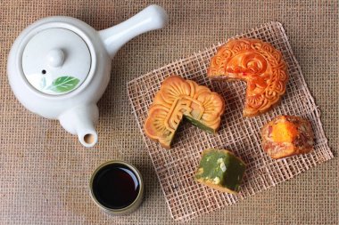 Yuvarlak mooncake8 tahıllar ve tuzlu yumurta ve squred mooncake dolu kırmızı fasulye, yeşil çay ve doğranmış macadamia fındık çay ve çaydanlık ile servis karıştırılır.