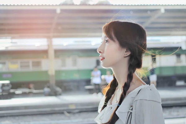 Hermosa joven adolescente de pie frente a la estación de tren . — Foto de Stock