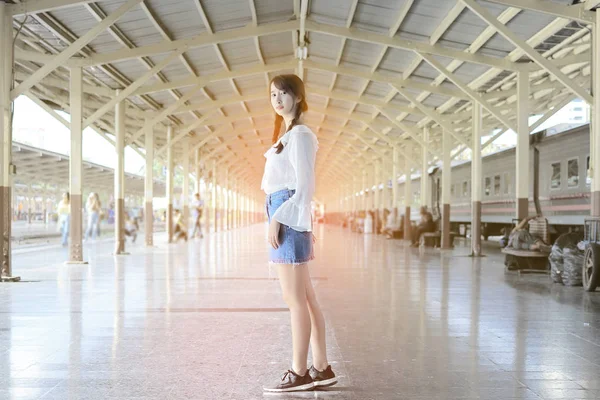 Hermosa joven adolescente de pie frente a la estación de tren . — Foto de Stock