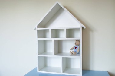 Oyuncak bebekli tahta bir bebek evi.