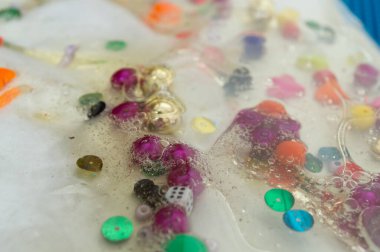 Şeffaf bir çantada renkli boncuklar.