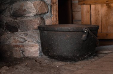 Üzerinde büyük bir geyik boynuzunun dinlendiği kaba yontulmuş duvarları ve sağlam ahşap tezgahı olan bir ahşap atölye. Geleneksel demirci ve ahşap işçiliği aletleri tezgahın etrafına dizilir.. 