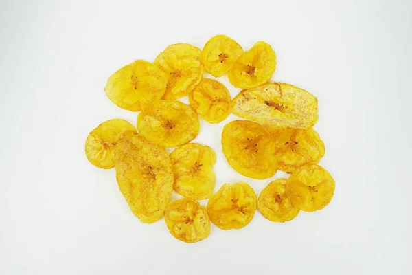 Doğal çerez sunumu için temiz beyaz arka planda dairesel düzende altın muz cipslerinin üst görüntüsü. Yiyecek konsepti