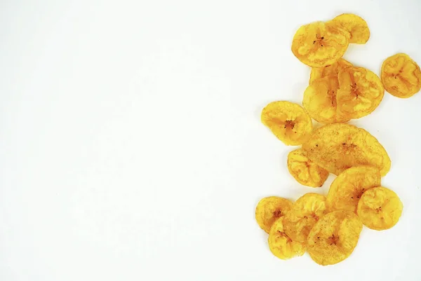 Temiz beyaz arka planda gevrek muz cipsleri ve abur cubur markası için boş fotokopi alanı. Yiyecek konsepti