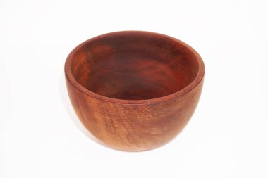 Koyu kahverengi ahşaptan yapılmış orta büyüklükte boş bir kase beyaz arka planda oturur..