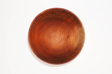 Üstü açık, koyu kahverengi ahşaptan yapılmış küçük bir kase beyaz arka planda duruyor..