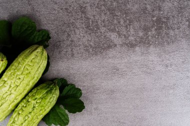 Gri arkaplanda yaprakları olan taze kavunlar ve kopyalama alanı