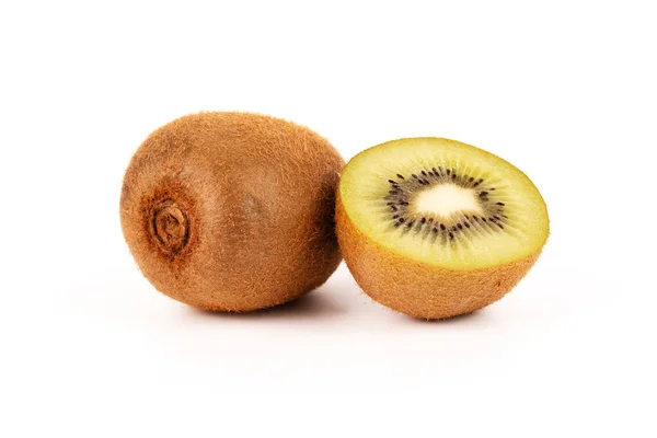 Dolu bir kivi meyvesi beyaz arka planda taze, dilimlenmiş bir kivinin yanında oturur..