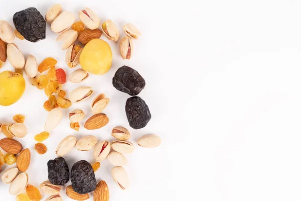 Karışık fındık ve kurutulmuş meyve yığını beyaz arka planın sol tarafına konur..
