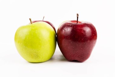 Beyaz arka planda sıralanmış yeşil ve kırmızı elmalar, sağlıklı meyve toplama