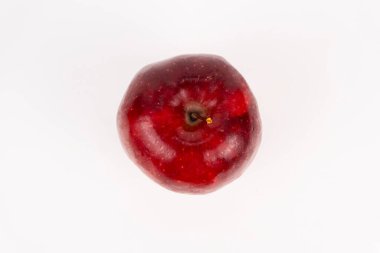 Tek başına duran parlak kırmızı bir elma, beyaz bir zemine karşı yeni bir şekil veriyor..