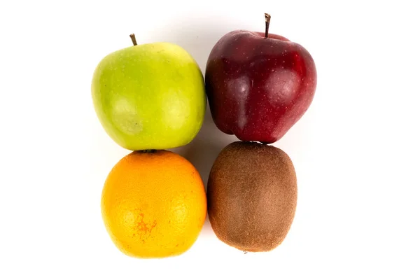 Kırmızı ve yeşil elma turuncu ve kivinin üzerinde oturur. Renkli sağlıklı beslenme planı gösterir..