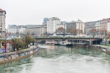 Avusturya 'nın Viyana kentinde, yağmurlu bir günde Donaukanal (Tuna kanalı) nehir kıyısındaki binalar ve ufuk çizgileriyle manzara. 