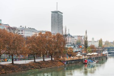 Avusturya 'nın Viyana kentinde, yağmurlu bir günde Donaukanal (Tuna kanalı) nehir kıyısındaki binalar ve ufuk çizgileriyle manzara. 
