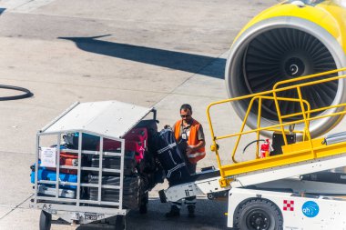Napoli uluslararası havaalanı Capodichino, İtalya 'da bavulu ya da bavulları taşıma bandına koyan işçiler