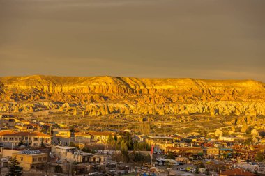 Kızıl Vadi ve Gül Vadisi ve Goreme şehir merkezi Kapadokya, Türkiye 'de günbatımının altında. Kızıl Vadi ve Gül Vadisi Kapadokyası isimlerini pembemsi kırmızı kayadan alır.  