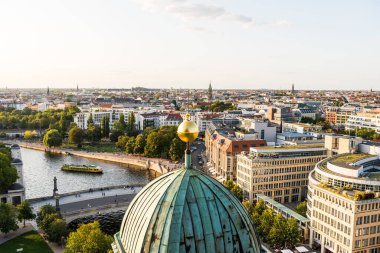Berlin şehir merkezinin modern ufuk çizgileri ile Spree Nehri 'nin nehir kıyısında ve günbatımının altında kilise kuleleri. Berlin Katedrali 'nden hava görüntüsü.