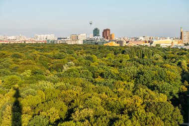 Berlin 'in panoramik şehir manzarası, Tiergarten, Berlin' deki Berlin Zafer Kolonu 'nun tepesinden, modern ufuk çizgileri ve yeşil ormanla.