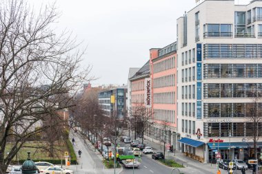 Berlin şehir merkezinin sokak manzarası, kışın modern bina ve ağaçla.