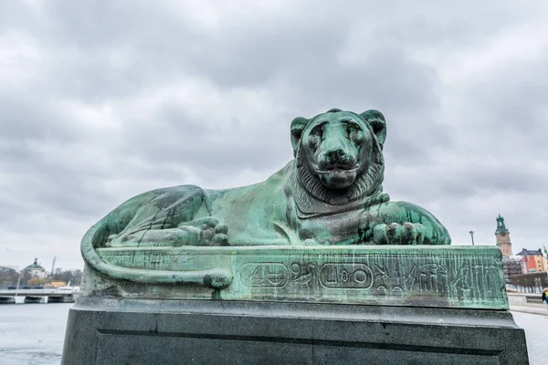 The North Bridge Norrbro bronze lion statue with egyptian hieroglyphics in the Old Town of Stockholm in front of the Parliament.