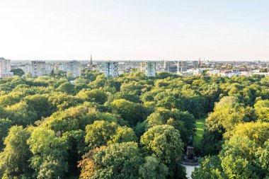 Berlin 'in panoramik şehir manzarası, Tiergarten, Berlin' deki Berlin Zafer Kolonu 'nun tepesinden, modern ufuk çizgileri ve yeşil ormanla.