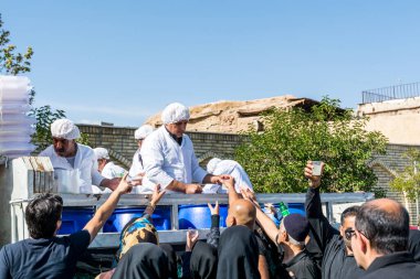 Gönüllüler, İran 'ın Şiraz şehrindeki Ashura festivalinde yerel halka yardım içkisi veriyor..