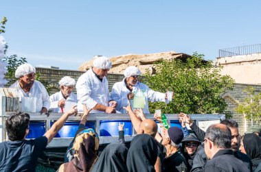 Gönüllüler, İran 'ın Şiraz şehrindeki Ashura festivalinde yerel halka yardım içkisi veriyor..