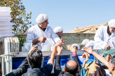 Gönüllüler, İran 'ın Şiraz şehrindeki Ashura festivalinde yerel halka yardım içkisi veriyor..