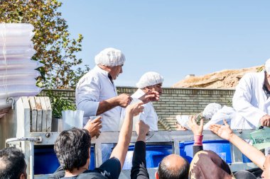 Gönüllüler, İran 'ın Şiraz şehrindeki Ashura festivalinde yerel halka yardım içkisi veriyor..