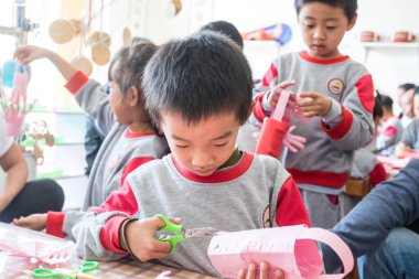 Halk anaokulundaki çocuklar Çin 'in Guangdong şehrindeki Shenzhen' de el işi yapıyorlar..
