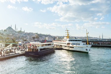 İstanbul, İstanbul 'daki Eminonu Rıhtımı' ndaki Eminonu İskelesi 'ne park eden Turist Gezisi gemisi, Süleyman Camii' nin arka planına sahip..