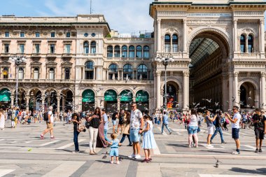 İtalya 'nın en eski alışveriş merkezi ve İtalya' nın başkenti Milan 'ın önemli bir simgesi olan Duomo ve Galleria Vittorio Emanuele II' nin önündeki meydanda bir turist..