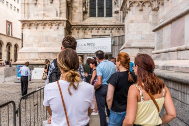 Milano Katedrali 'nin (Duomo di Milano) girişinde güvenlik kontrolü bekleyen turistler, İtalya' nın Lombardiya katedrali. Aziz Mary 'nin doğuşuna adanmıştır..