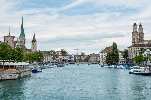 View of the historic buildings and bridge of Zurich at the bank of Limmat River and Zurich lake, with landmark of Fraumnster Church clock tower, Grossmunster Great Church and church tower of St. Peter Pfarrhaus