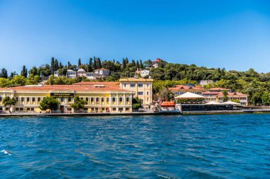 Türkiye 'nin İstanbul kentindeki İstanbul Boğazı' nda yaz mevsiminde yeşil ormanlı güzel binalar ve malikaneler. Bir Gemi Gezisinden Görünüm.